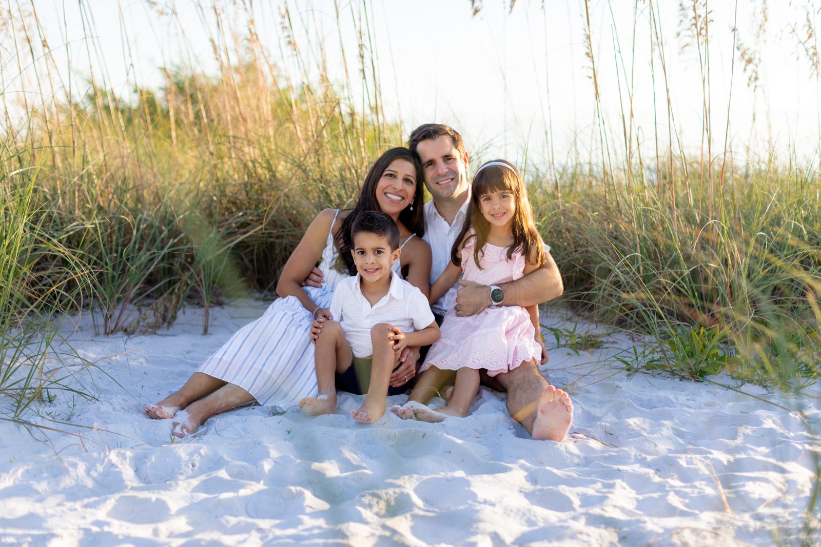 Dr. Priya Mathews with her husband and two children on the beach